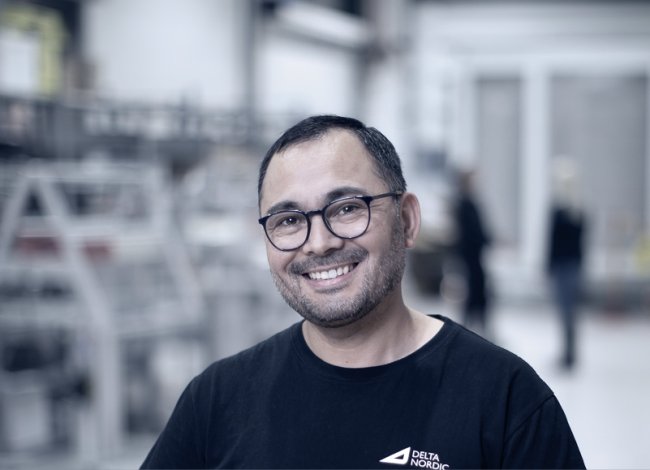 DeltaNordic söker en Beredare. Bilden visar en glad kille.